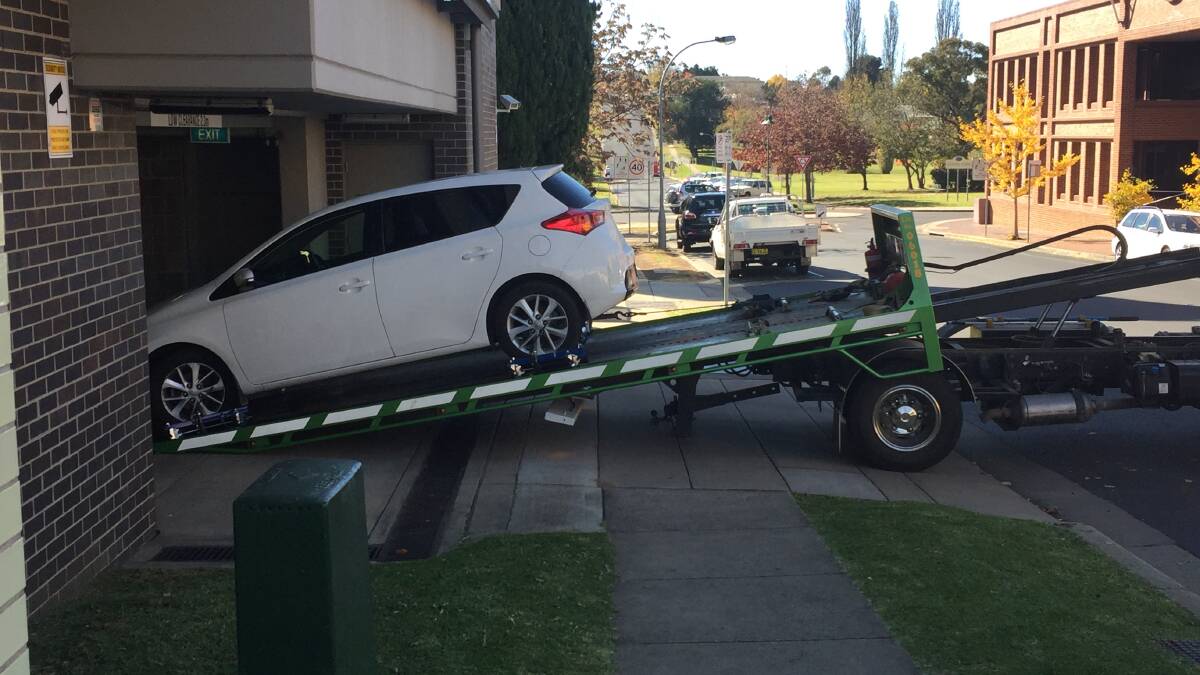 Seized: The stolen white Toyota Corolla is unloaded at Armidale Police Station where it will undergo forensic examination.