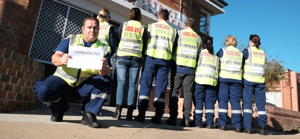 WHERE IT BEGAN: The July 2016 silent protest about the entitlements slash, when NSW ambulance officers inserted an 'Unprotected' sign in their fluro vests. Photo: Michèle Jedlicka