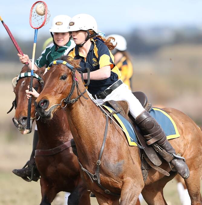 RIDING TO WIN: Junior player Gemma Stuart gets the ball away from an opponent at the NSW polocrosse zone championships. Photo: Daniel Bennett