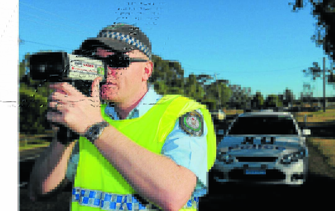 SPEEDSTERS NABBED: Oxley highway patrol Senior Constable Richard Hooley tests driver speed along Scott Rd during a police operation. Photo: Geoff O'Neill 