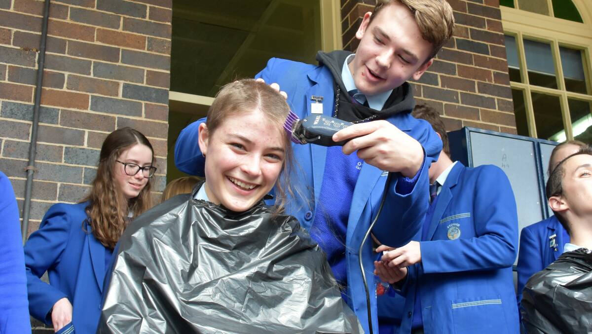 CLOSE SHAVE: O'Connor Catholic College student Isabelle Stoessel trusted Sebastian Battersby with the clippers, as part of the school's fundraising campaign. Picture: Meg Francis