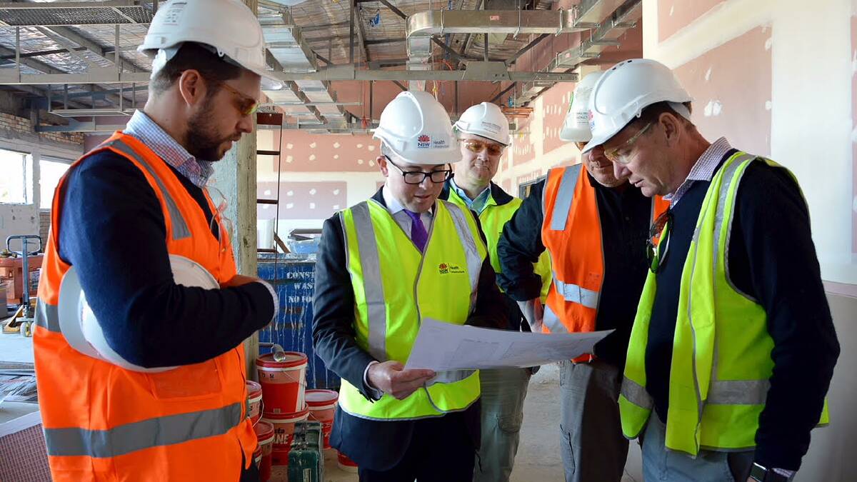 Redevelopment project manager James Croft, left, Northern Tablelands MP Adam Marshall, Richard Crookes Construction site managers Bear Melvey and John Brookes and NSW Health Infrastructure senior project director Mark Brockbank looking over plans in the new day surgery unit, under construction.
