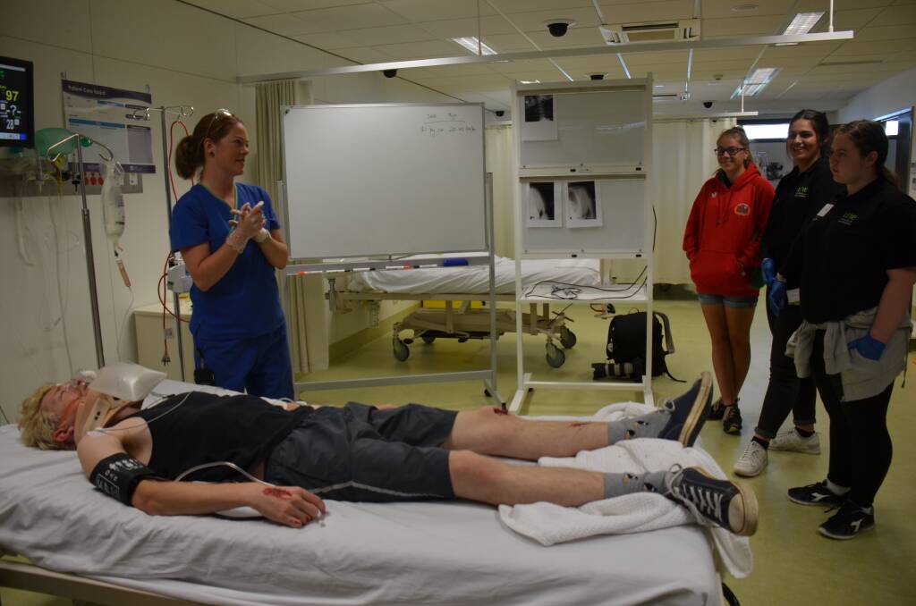 REAL-WORLD MEDICINE: Students assess a simulated patient who has been made-up with injuries under the guidance of emergency staff, Ben and Alison, who show pupils what to do once the patient arrives in the ED.
