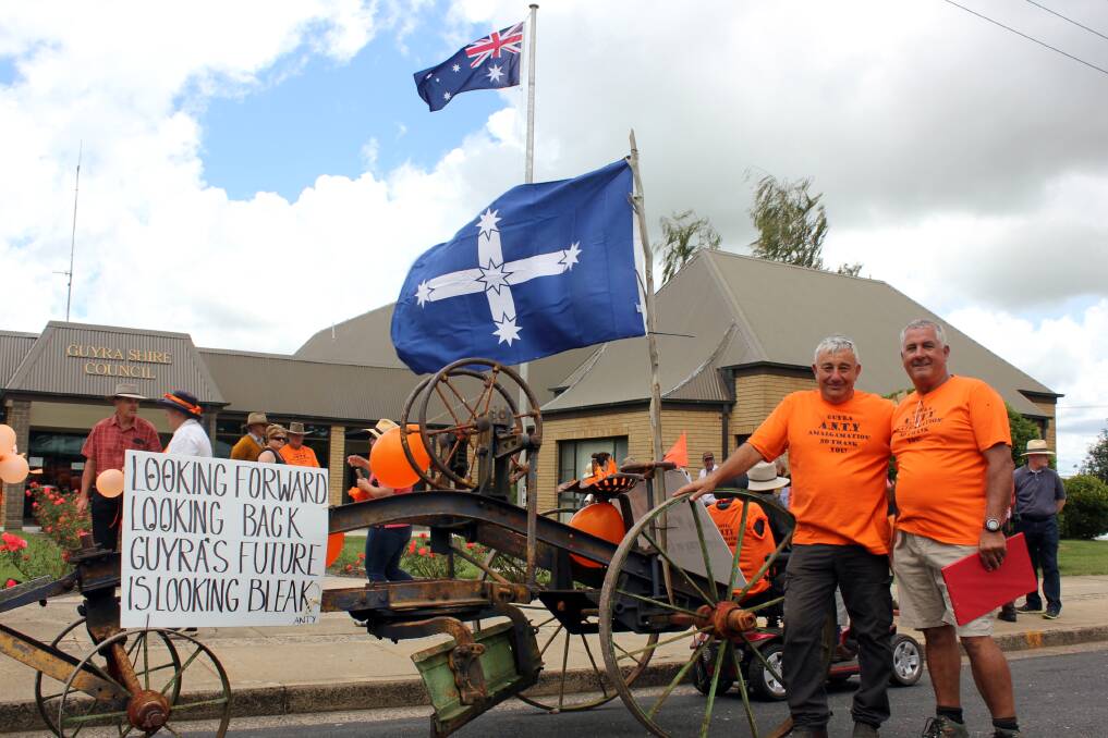 FIGHTING BACK: Guyra residents dressed in orange rally in front of the former council building earlier this year, in protest of forced council amalgamations. Photo: Madeline Link.