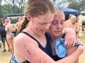 Isabella Henderson, first out of the water for TAS, is given a congratulatory hug by  swimming captain Prudence Black, who was second girl home for TAS. 