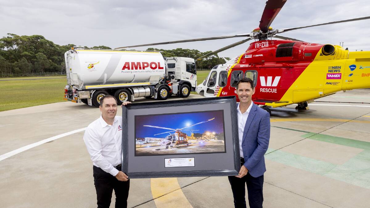 Westpac Rescue Helicopter Service Acting CEO James Lawrence, with Ampol General Manager Business to Business Brad Phillips, at the Services Belmont base for the official contract signing, with the backdrop one of the Services AW139 aircraft and a Westpac Rescue Helicopter Service branded Ampol fuel truck.