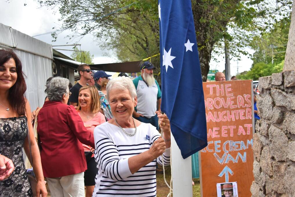 Sue Adams raises the flag on Australia Day, watched by Liz Deep-Jones.
