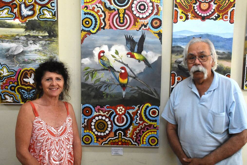  ARTISTS: Kay Smith and Brian Irving, with their "Eastern Rosellas" painting. Photo: Nicholas Fuller
