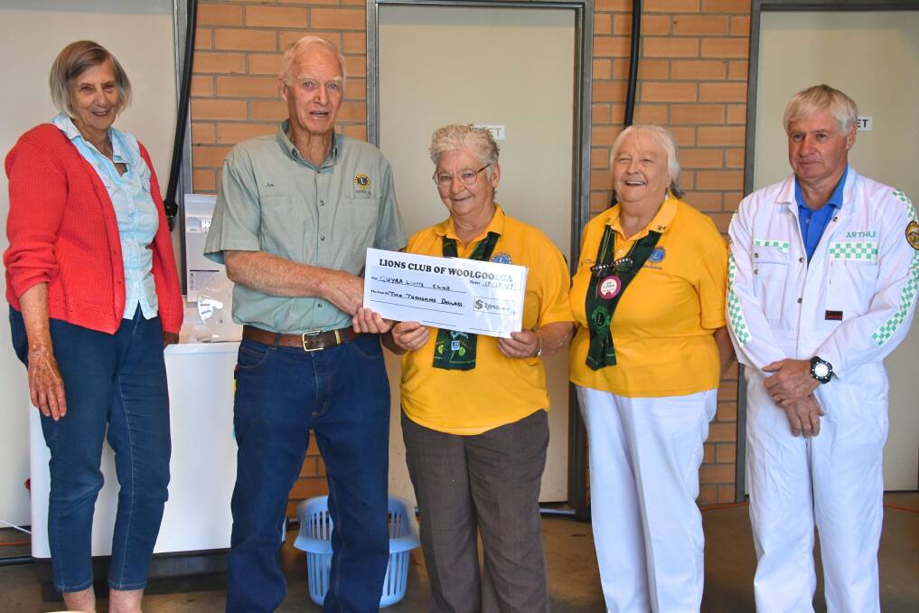 HELPING OUT: Leigh Ramage does her washing at the VRA's new laundromat, while Jean Vickery and Joy O'Shea from the Lions Club of Woolgoolga present a cheque to Jim Betts (Lions Club of Guyra) and Arthur Atkins (Guyra VRA). Photo: Nicholas Fuller