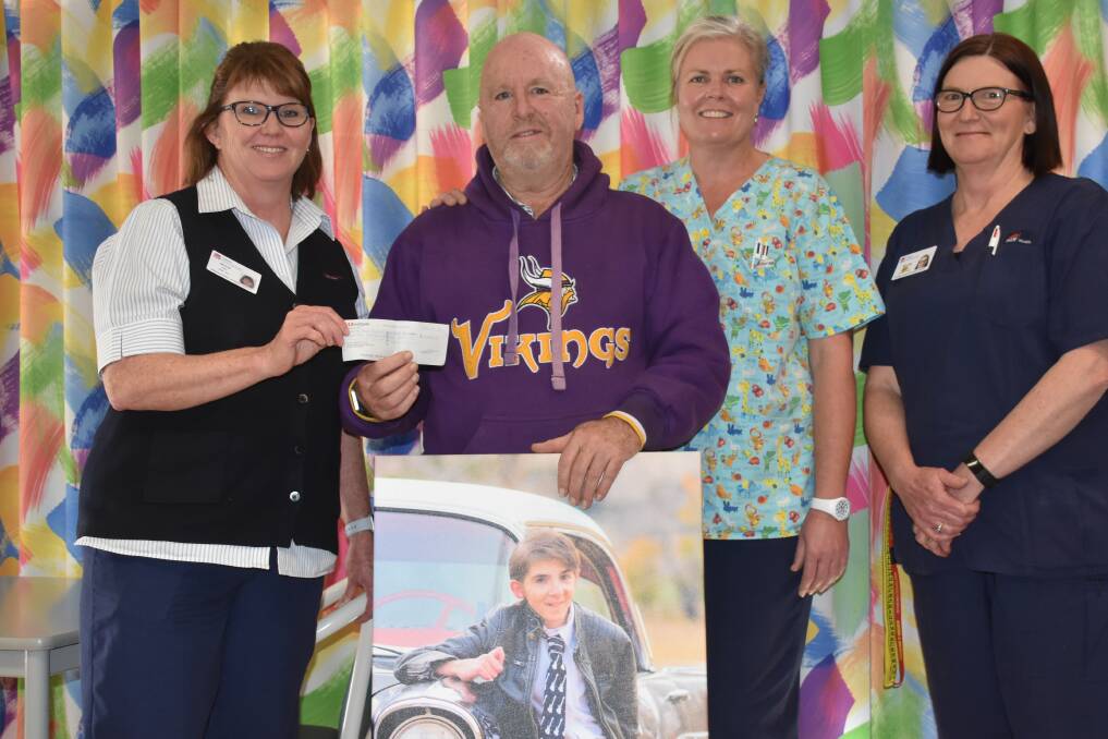 Tony Bush gives his late foster son's legacy to acting director of nursing Megan Hay, watched by nurses Kylie Matthews and Helen Yeates. Photo: Nicholas Fuller