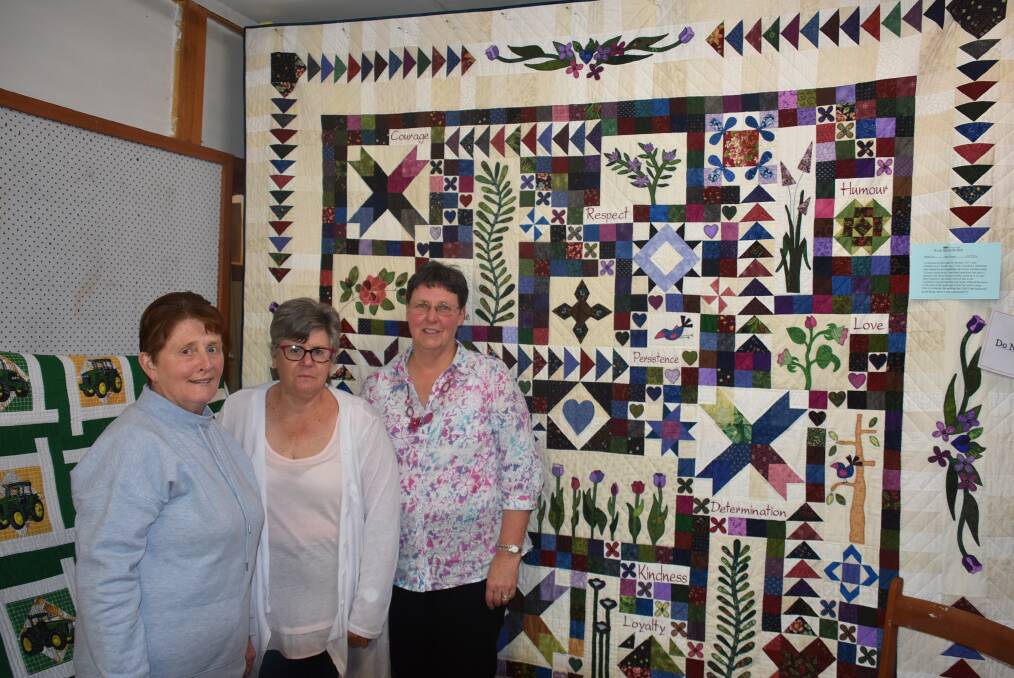Lorraine Clark, Sharyn Holt, Robin Godlonton with one of the quilts. Photo: Nicholas Fuller