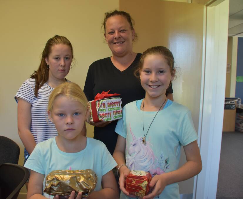 Amanda McDonnell with daughters Savannah Kempton (14), Piper Kempton (9), and Rubi Swilks (8), with gifts at the Reverse Advent Giving Project. Photo: Nicholas Fuller