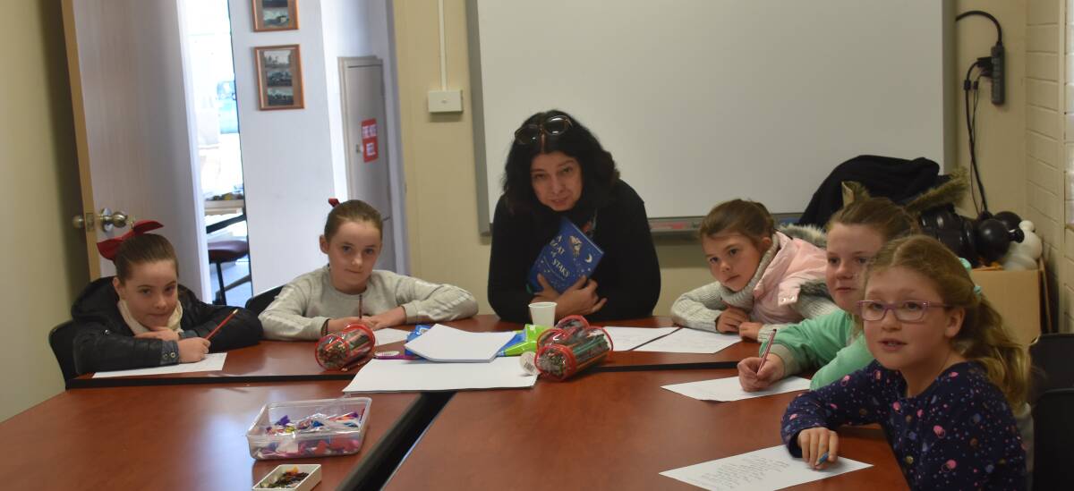 BUDDING POETS: Local writer Sophie Masson teaching Guyra students how to write and illustrate poems. Photo: Nicholas Fuller