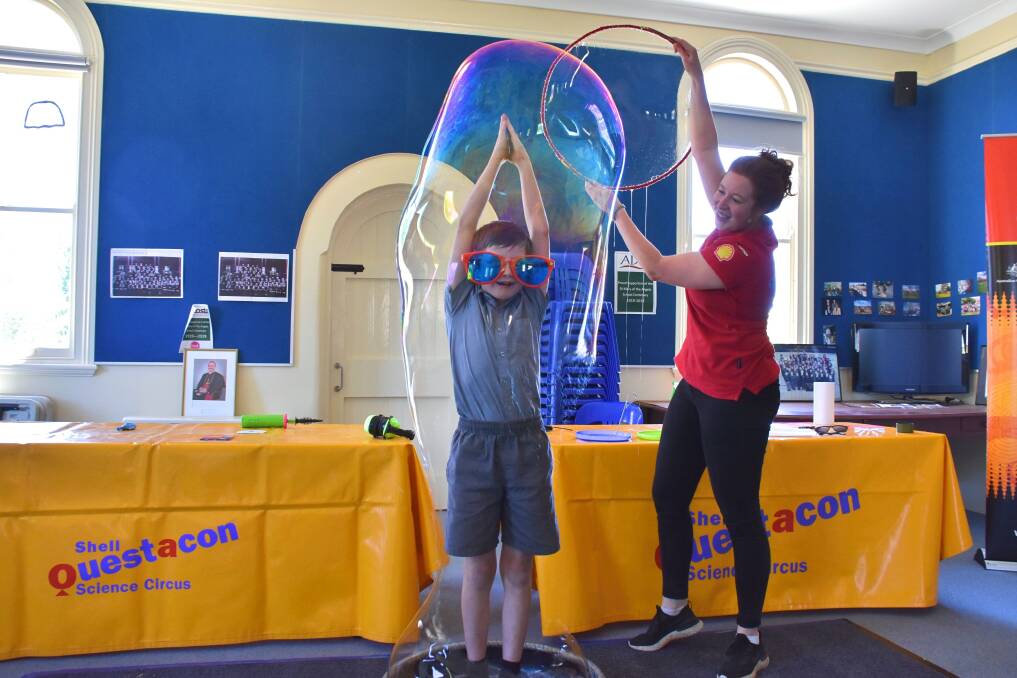 IN FILM: Questacon presenter Hannah Thomas puts Year 5 student Archie Jackson in a bubble. Photo: Nicholas Fuller